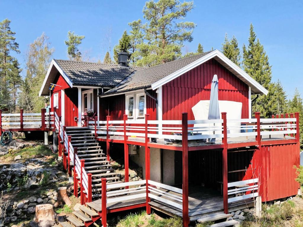 una casa roja con una valla delante en Holiday home by the lake, en Tived