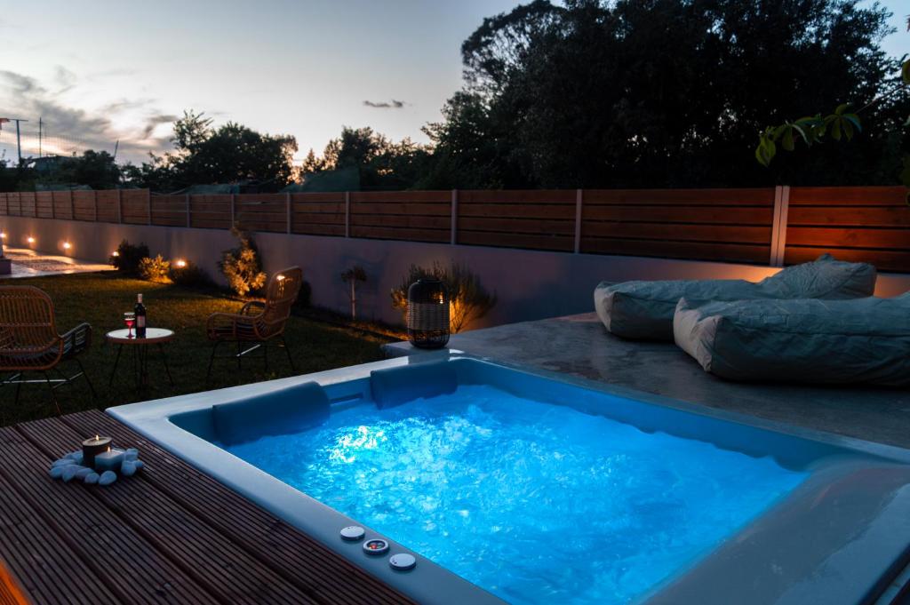 a hot tub in a yard with a patio at Averto House Lefkada in Lefkada Town