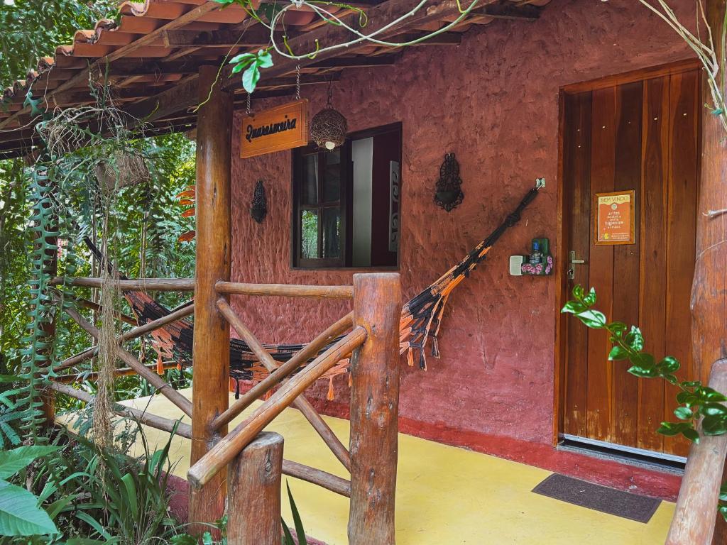 una entrada a un edificio rojo con una puerta de madera en Hospedagem Donalu - Vale do Capão, en Vale do Capao