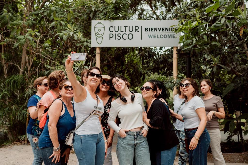 a group of women standing in front of a sign at Hotel Culturpisco in Ica