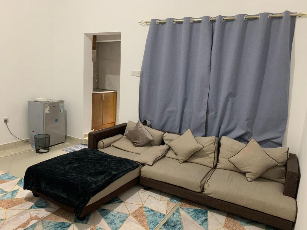 ein Sofa im Wohnzimmer mit einem blauen Vorhang in der Unterkunft The theatre room in Abu Dhabi