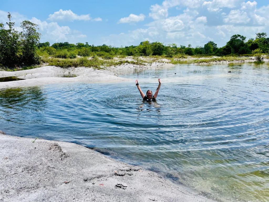 a man swimming in a river with his arms in the air at Land of Promise - Reggae Escape in Zanderij