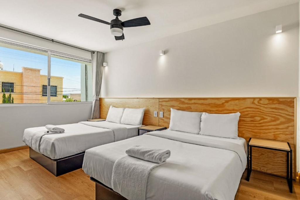two beds in a room with a window at Musgo by Homi Rent in Laborcillas