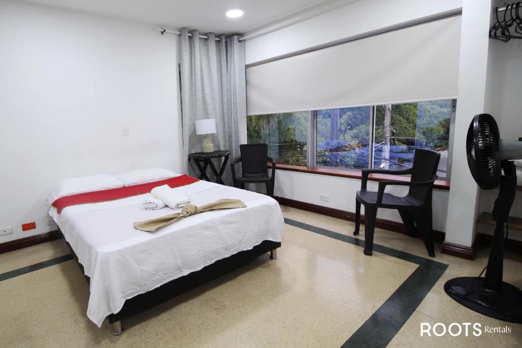 a bedroom with a bed and a desk and a window at Apartamento privado en Medellin MAG301 in Medellín