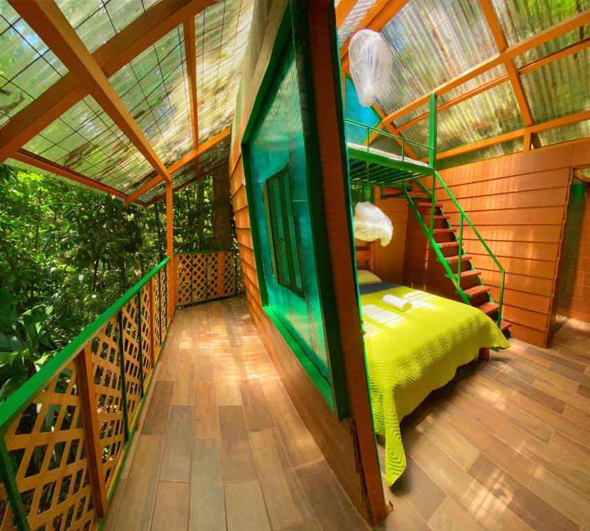 a room with a green bed in a house at Las Arrieras Nature Reserve and Ecolodge in Horquetas