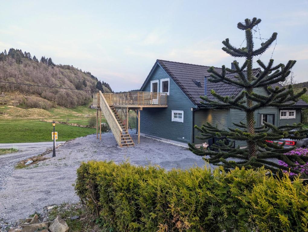 a house with a wooden deck and a staircase at Countryside experience in a Cozy Loft Near Bergen in Frekhaug