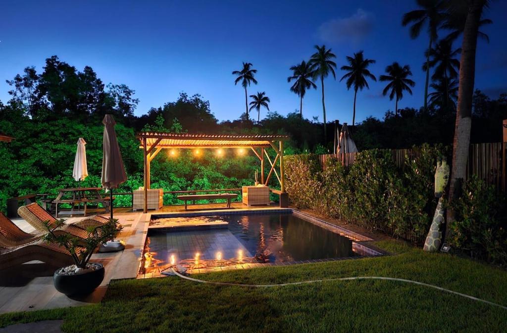 Toquinho · Casa de Luxo c/ piscina em cond fechado - Toquinho في إيبوجوكا: حديقة خلفية بها مسبح وشرفة