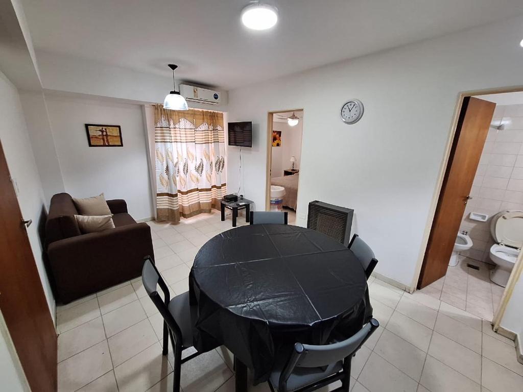 ein Wohnzimmer mit einem schwarzen Tisch und einem Sofa in der Unterkunft Bahía x día 1 in Bahía Blanca