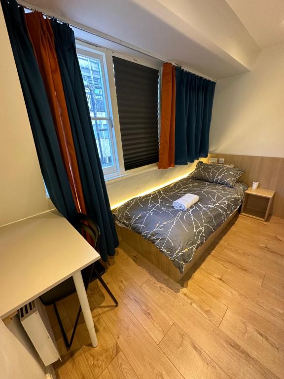 a small bedroom with a bed and a desk at Not very quiet but best Location in London