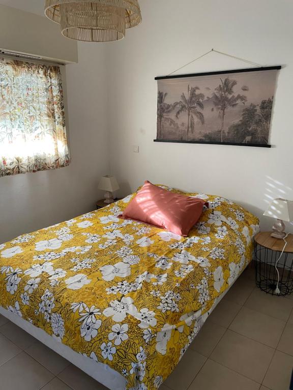 - une chambre avec un lit et une couette jaune dans l'établissement Charmant T2 climatisé proche Calvi centre, à Calvi