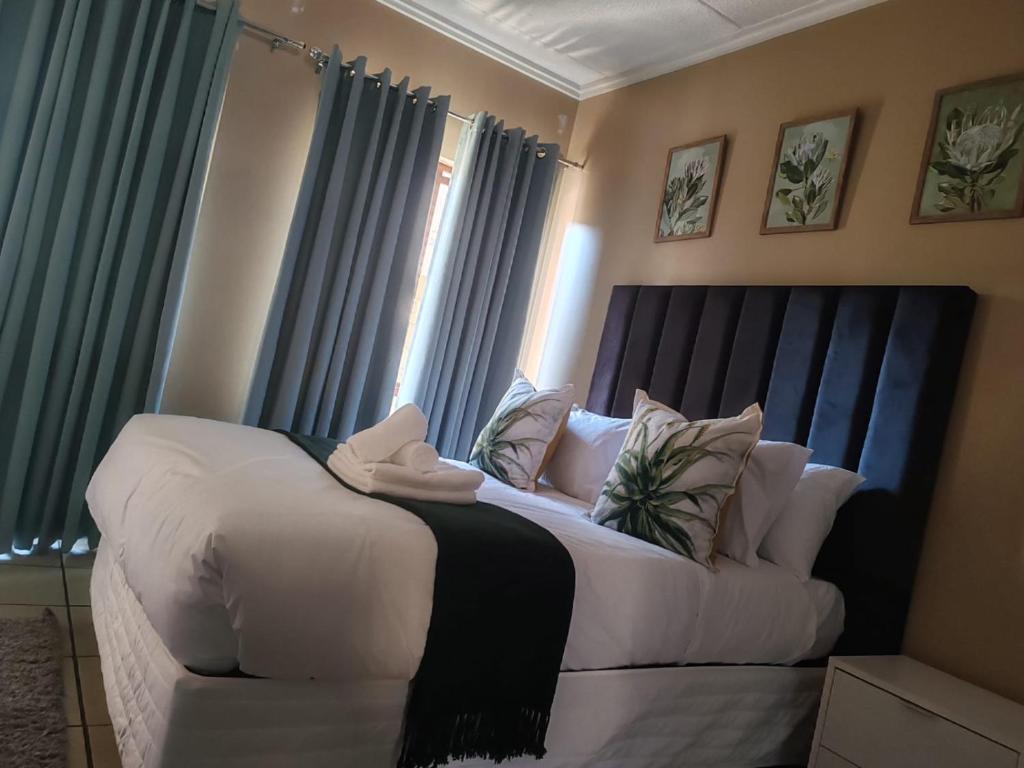 a large white bed in a room with windows at Grace Haven in Sandton