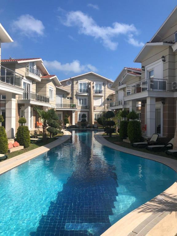 a swimming pool in front of some apartment buildings at Pine Golf Village Belek in Belek