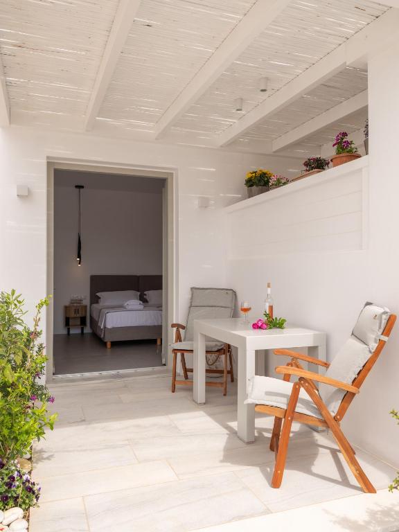 eine Terrasse mit Tisch und Stühlen und ein Schlafzimmer in der Unterkunft Studio Busho in Naoussa