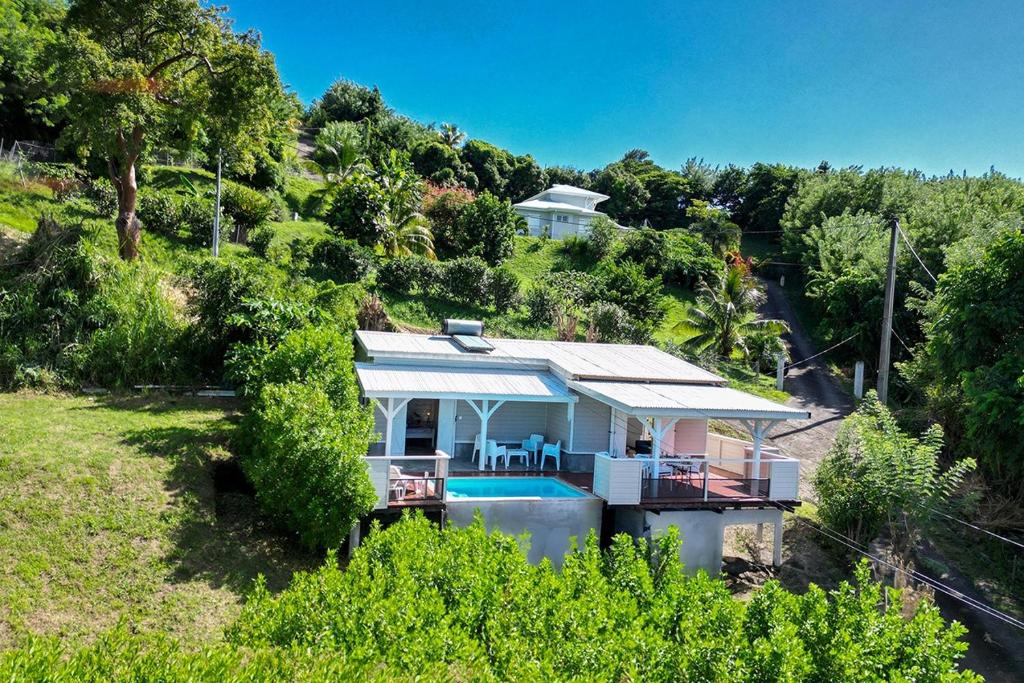 uma casa com piscina numa colina com árvores em Ti Sunset 2 Martinique Le Carbet em Le Carbet