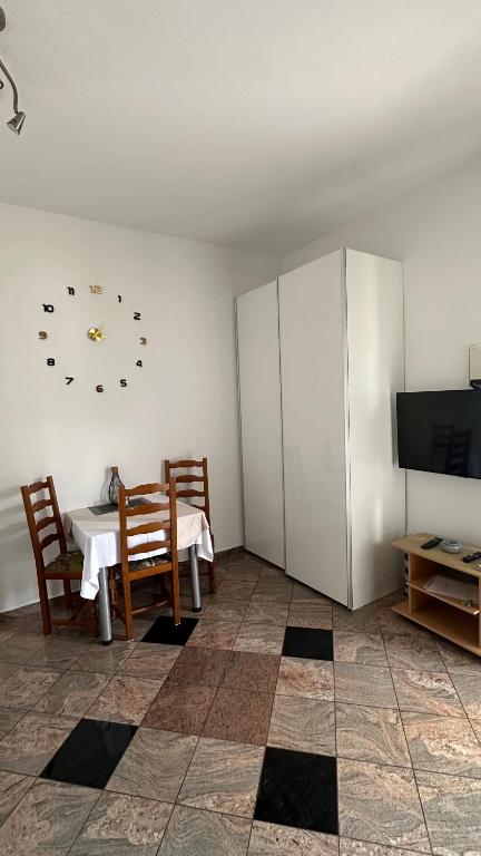 a dining room with a table and a clock on the wall at Villa Baldi -Apartmani Danny in Tar