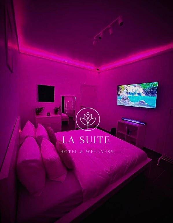 Dieses lila Zimmer verfügt über ein Bett und einen TV. in der Unterkunft La Suite Liege in Seraing