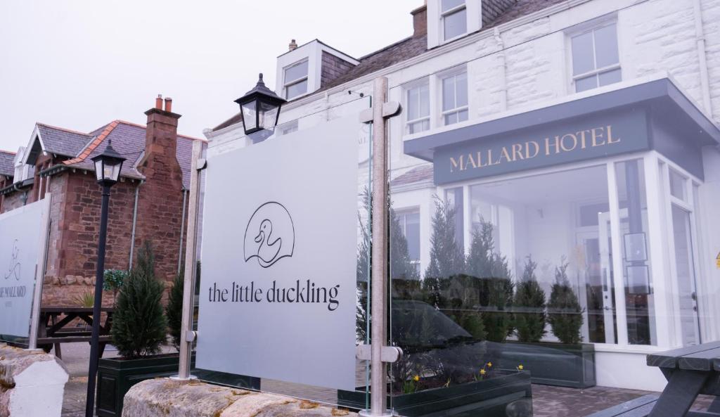 a sign in a window of a white building at The Mallard Hotel in Gullane