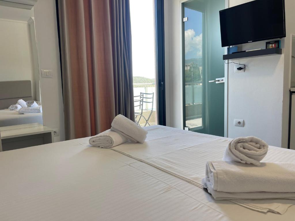 a hotel room with a bed with towels on it at Vila Olserd Shehu in Ksamil