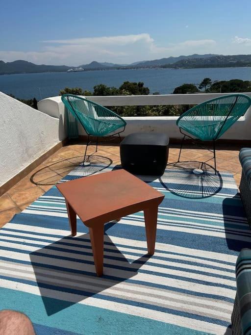 un patio avec deux chaises, un banc et une table dans l'établissement Villa cosy, Porto-vecchio 150m mer, à Porto-Vecchio