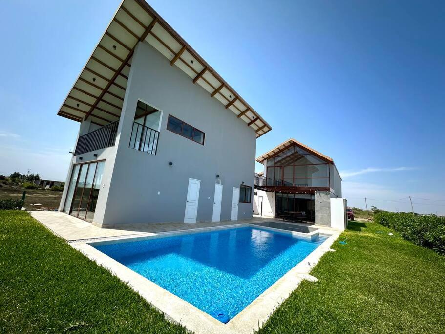 una casa con piscina frente a ella en Camelia Chincha® Hermosa Casa de Playa y Campo en San Pablo