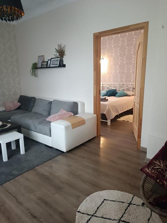 sala de estar con sofá y dormitorio en Marta's Apartment, en Kuldīga