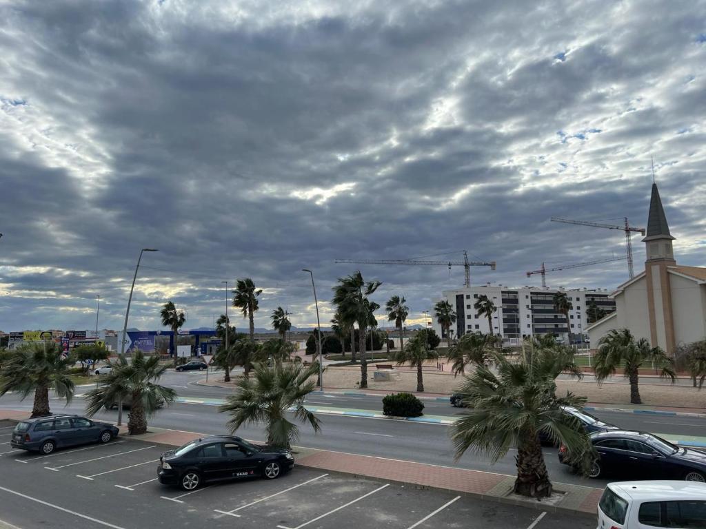 een parkeerplaats met auto's geparkeerd voor een kerk bij LOS1-VAO Holiday Rentals- Los Alcazares near Roda Roundabout in Los Alcázares