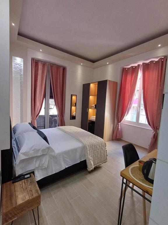 1 dormitorio con 1 cama y 2 ventanas con cortinas rojas en La Siesta, en La Spezia