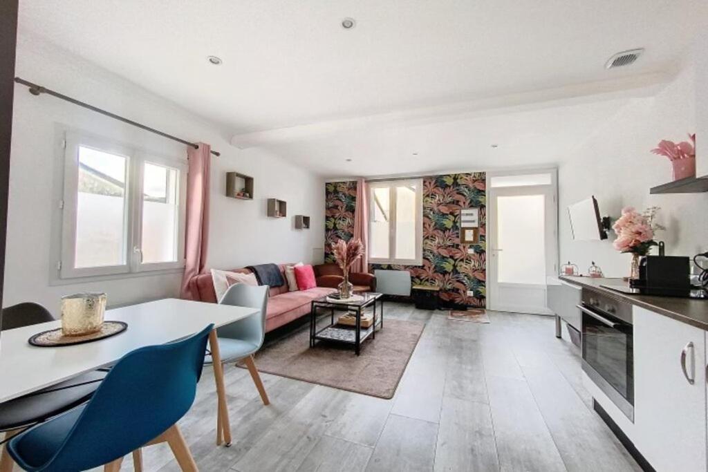 eine Küche und ein Wohnzimmer mit einem Tisch und Stühlen in der Unterkunft Maison avec terrasse à quelques minutes de la place Morny in Deauville