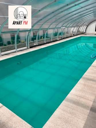 a swimming pool with blue water in a building at Apart Pm Casa de playa in Necochea