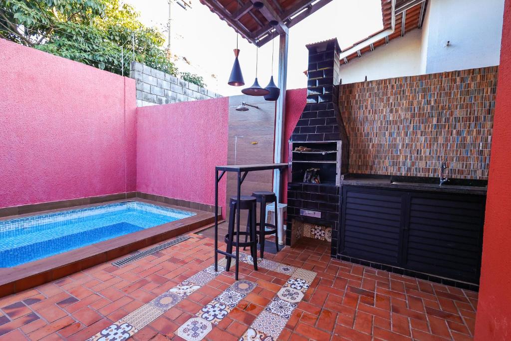 uma banheira de hidromassagem numa casa de banho cor-de-rosa com uma mesa e cadeiras em Casa aconchegante em Goiânia em Goiânia