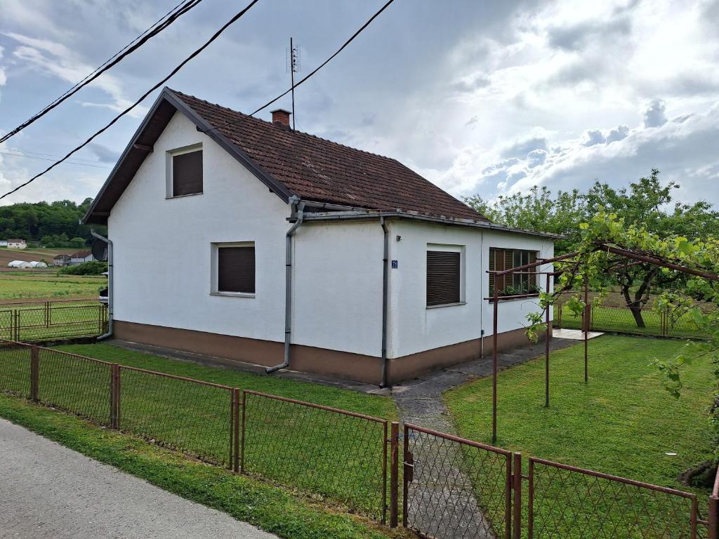 Uma casa branca com uma cerca à volta. em Stefin kutak em Bosanski Novi