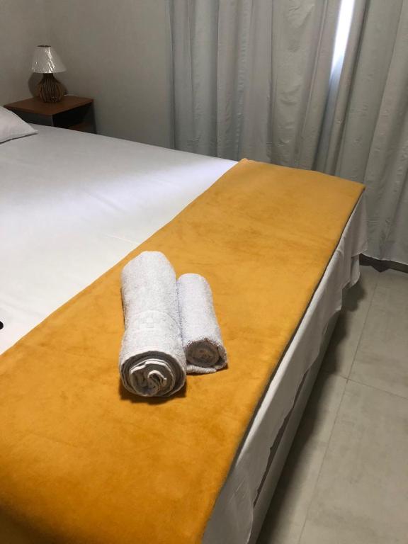 a pair of towels sitting on a bed at Quarto privativo 01 in Sinop