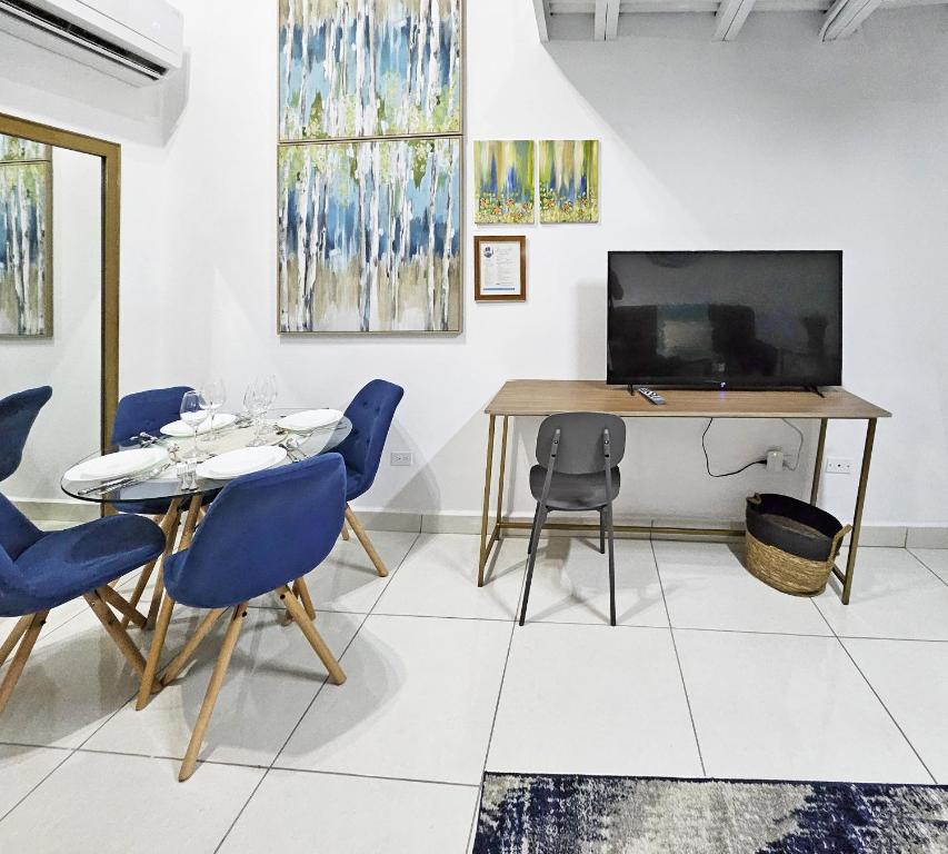 uma sala de jantar com uma mesa e cadeiras e uma televisão em Loft Moderno y Tranquilo # 7 na Cidade do Panamá