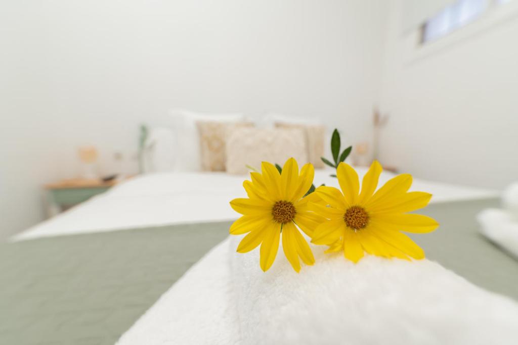 two yellow flowers sitting on top of a bed at Casa El Drago 1 in Breña Baja