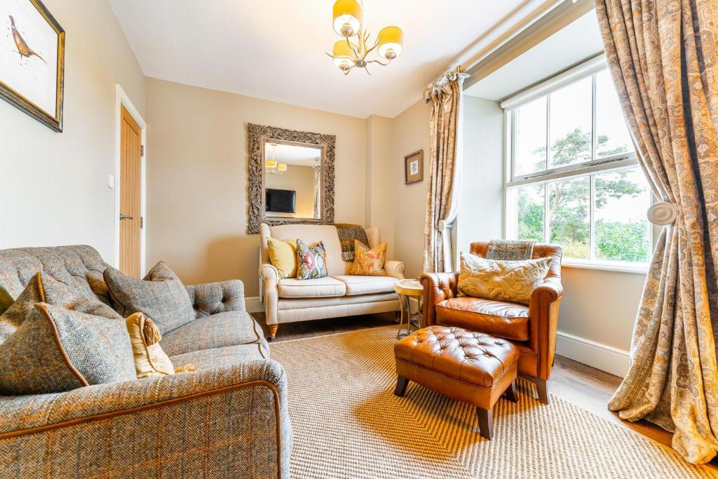 een woonkamer met een bank en stoelen en een raam bij Dell Cottage in Ambleside