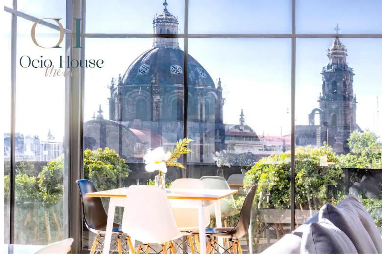 een tafel en stoelen voor een gebouw bij SUPERMODERNO En Pleno Centro Histórico in Mexico-Stad