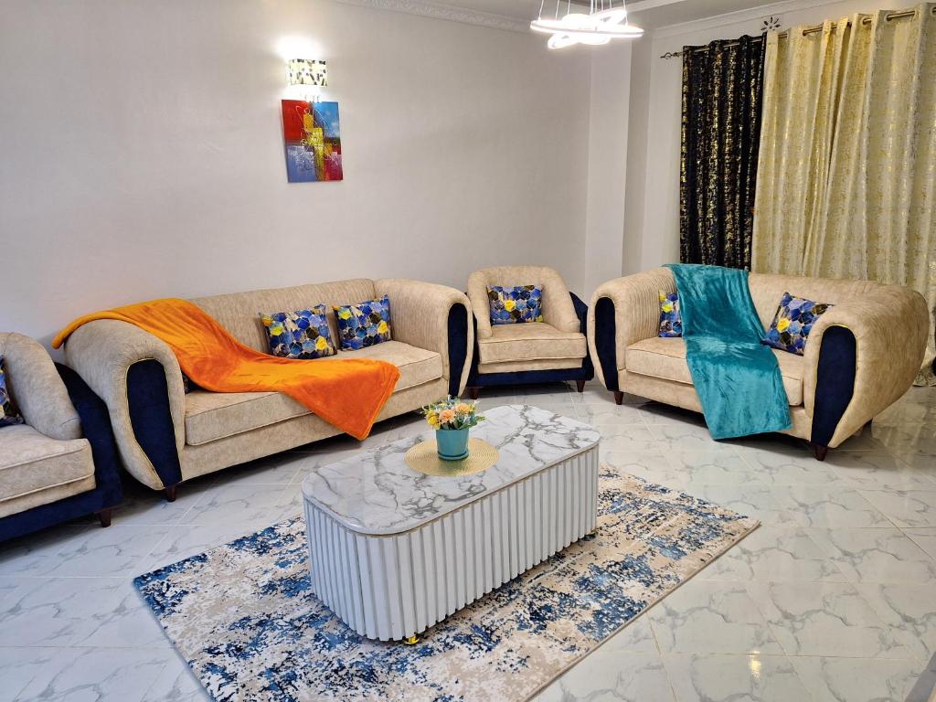 uma sala de estar com sofás e uma mesa em Mellow Homes 3 - Own compound em Kitengela 