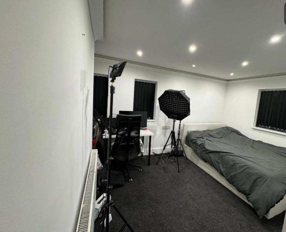 a bedroom with a bed and a desk with a camera at Holiday double room in Nottingham