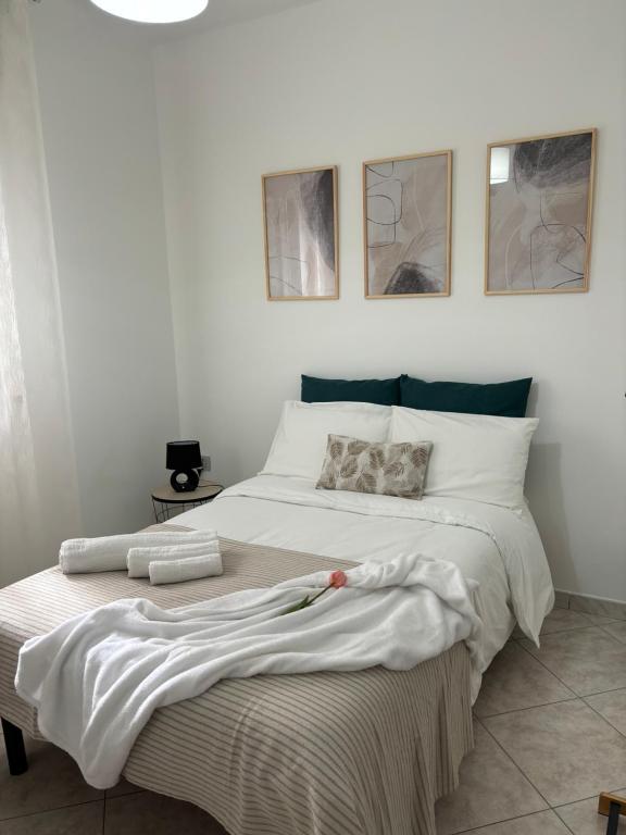 una camera da letto con un grande letto bianco con tre immagini sul muro di La Fenice Luxury a Surbo