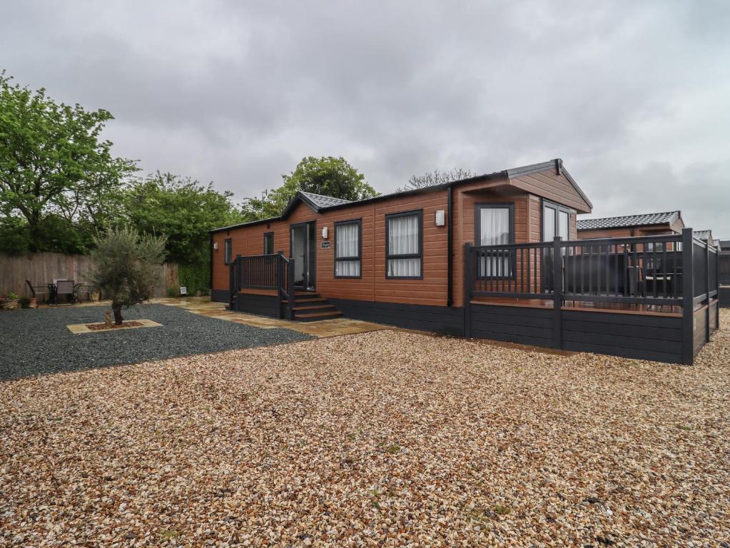 a log cabin with a porch and a deck at Cotswold Cwtch in Evesham