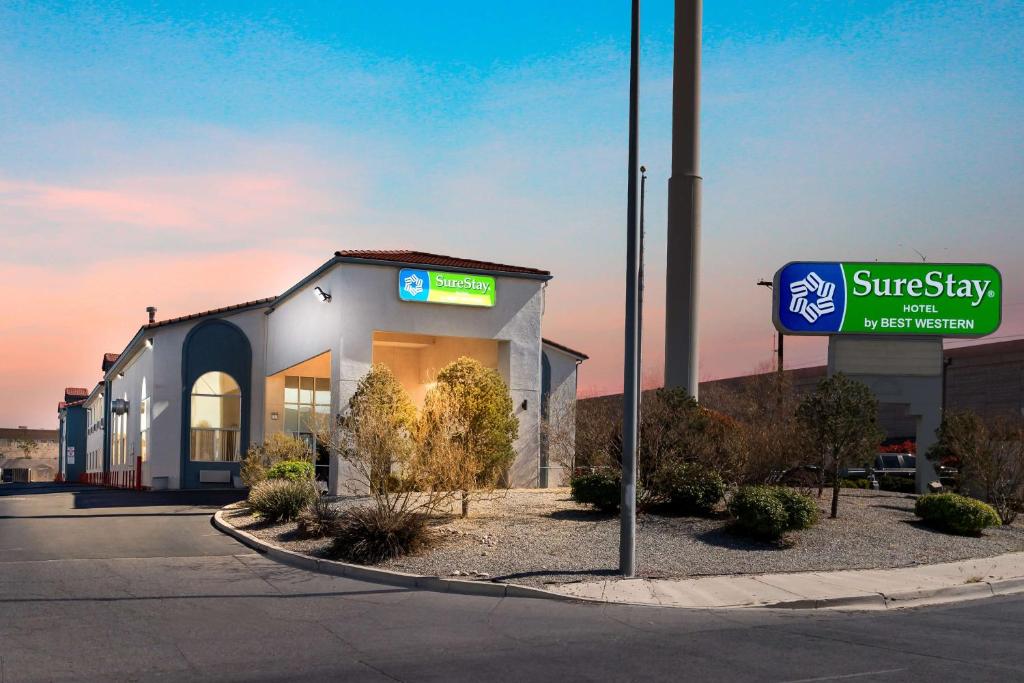 a building with a sign in front of a store at SureStay Hotel by Best Western Albuquerque Midtown in Albuquerque