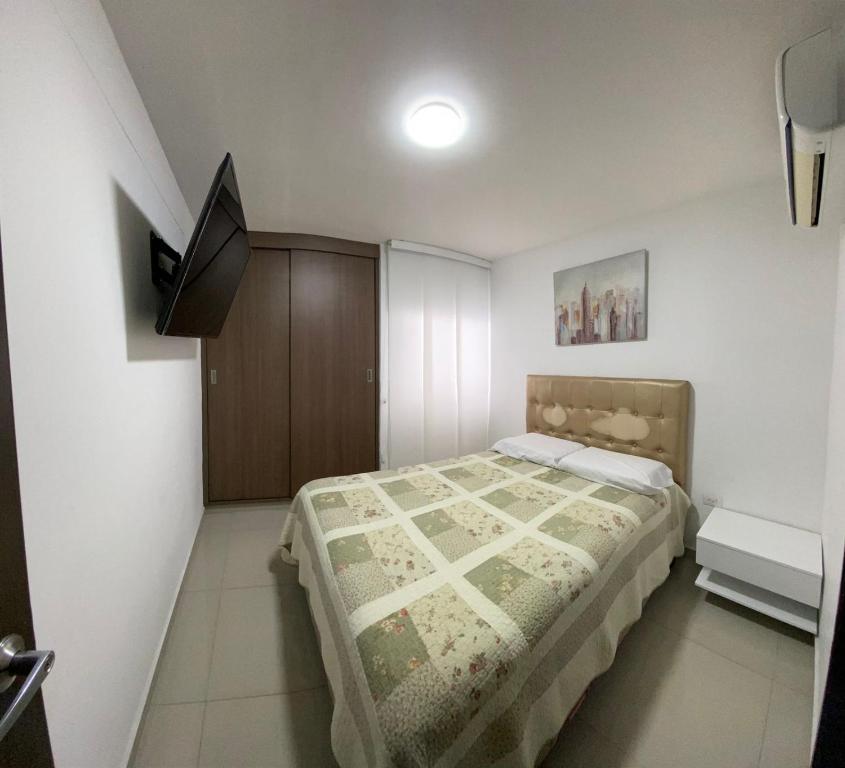 a small bedroom with a bed and a cabinet at Hermoso apartamento con zona social in Los Patios