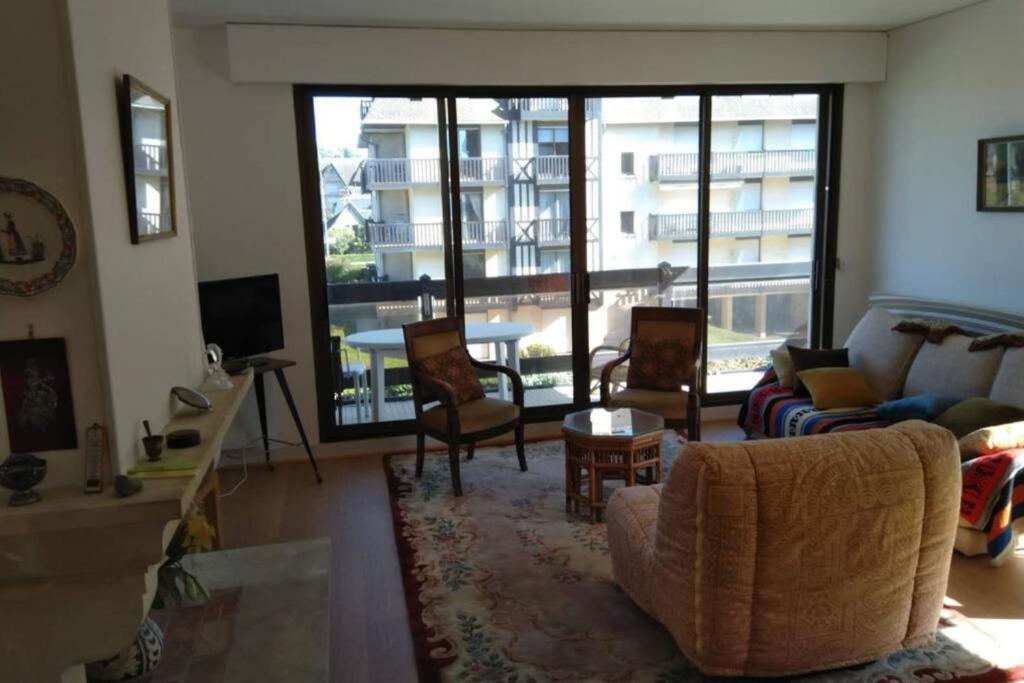 un salon avec un canapé et des chaises dans l'établissement Spacious apartment in front of the sea, à Deauville