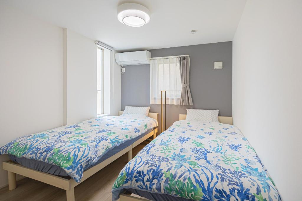 a bedroom with two beds and a window at 渋谷 広め50m2 2LDK 代々木公園駅徒歩5分 家族におすすめ in Tokyo