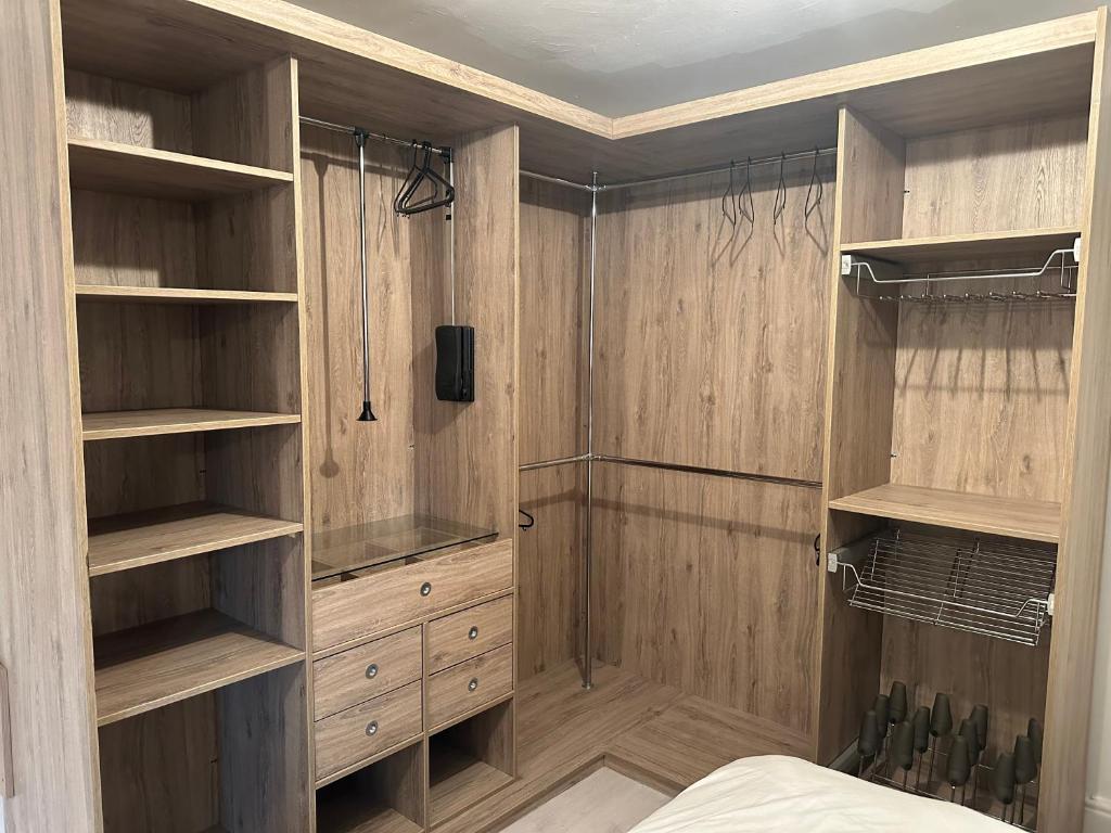Luxury en-suite bedrooms في ساوثهامبتون: غرفة نوم بجدران خشبية ورفوف خشبية