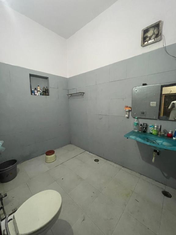 Hotel Aspiration في Tājganj: حمام مع مرحاض ورف أزرق
