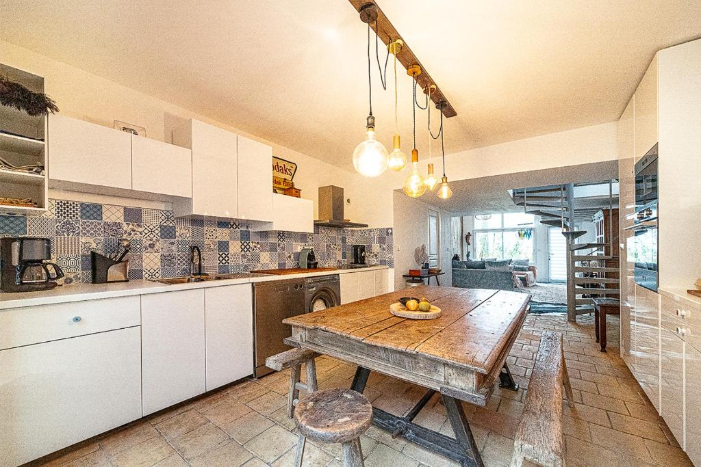 une cuisine avec une table en bois au milieu dans l'établissement Villa Pita, Piscine au cœur des Goudes, à Marseille