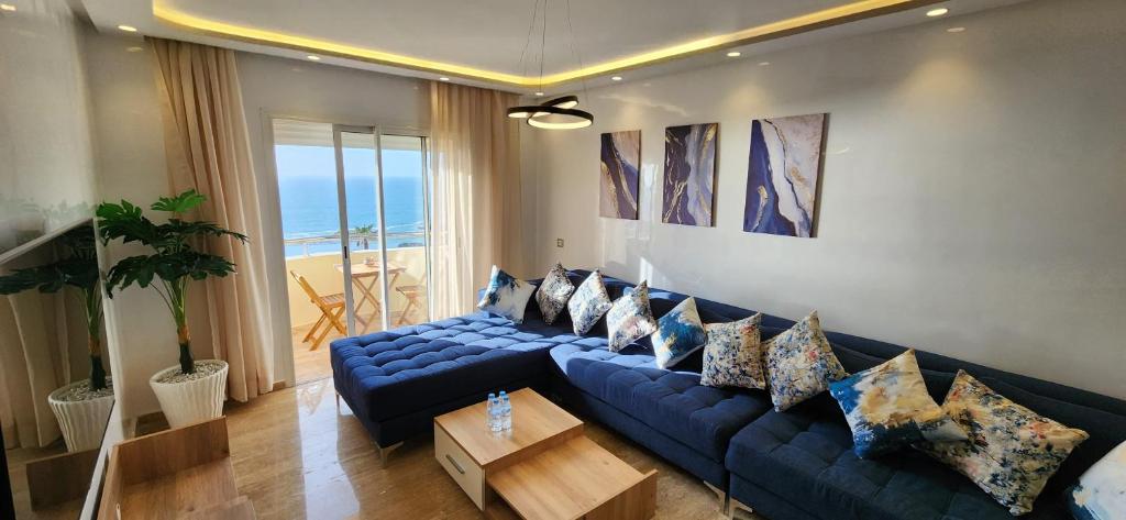 - un salon avec un canapé bleu et une table dans l'établissement Beautiful beachfront apartment, à Rabat