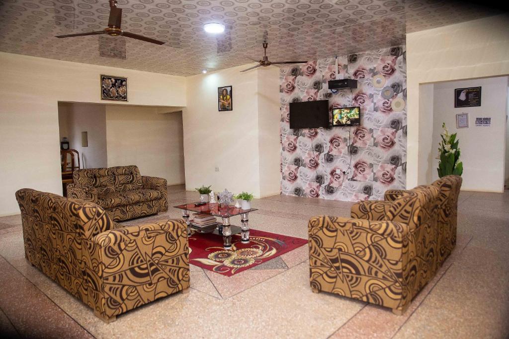 sala de estar con 2 sillas y mesa en JaneChill Guest House, en Accra