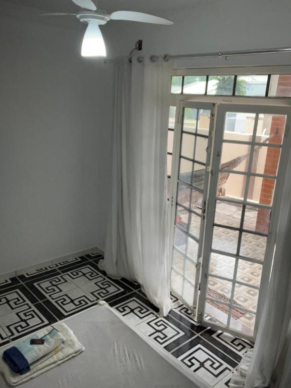 Habitación con ventana, cortinas blancas y suelo. en Quarto Sr. Formiga Ceres0024 en Cuiabá